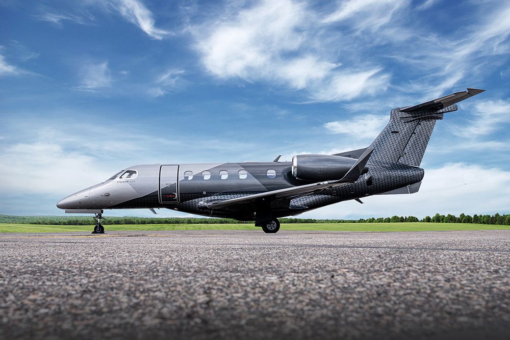 Dark gray light jet shown side-on on an airport apron